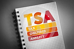 TSA - Tax-Sheltered Annuity acronym on notepad, business concept background