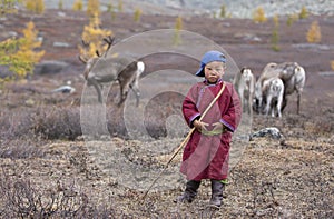 Tsaatan boy, dressed in a traditional deel playing outside photo