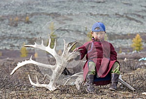 Tsaatan boy, dressed in a traditional deel with a reindeer horn