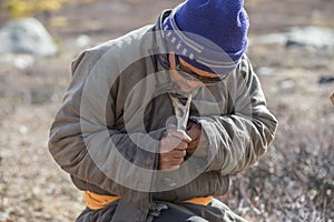 Tsaatan man carving a reindeer horn