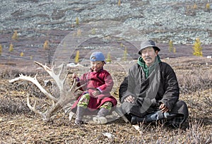 Tsaatan nomadic boy and his grandfather in a traditional deels r