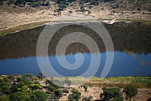 TSHWAING METEORITE IMPACT CRATER WITH SURROUNDING SLOPING AREAS AND WATER AT THE BOTTOM