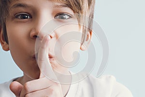 Tsss! Boy shows gesture that you need to observe silence