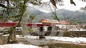 TSUWANO,JAPAN - NOVEMBER 28,2018: Visitors waiting to take a picture of a red train running through a bridge in tsuwano while sno