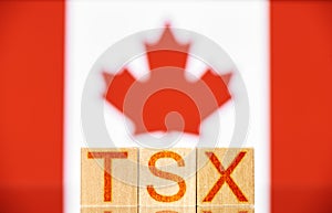 Tsx. wooden blocks with tsx lettering on canada flag background.