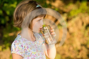 Little girl kid with glass of water in morning, drink every day