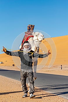 Tuareg man posing with his dromedary