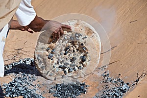 Tuareg man preparing the traditional bread photo