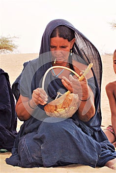 TUAREG WOMAN PLAYING LAUD IN THE SAHARA