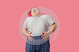 Tubby man laughs happily, with his hands on belly, expresses positive emotions.