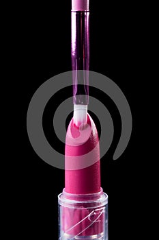 Tube of lipstick with a brush make-up on black