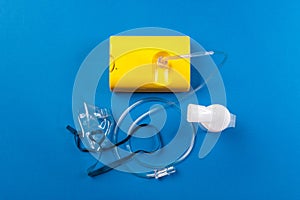 Tube mask nebulizer and tubular transparent cable on blue background, disease cold, flu