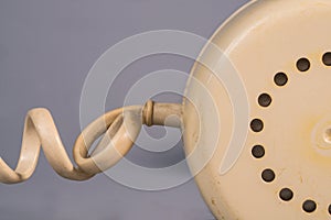 Tube from an old rotary landline phone. Macro shot of a yellow plastic telephone receiver with round holes. Removed