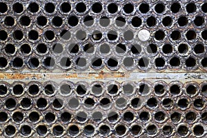 Tube sheet plate of heat exchanger or boiler closeup texture macro background with disconnected muted clogged leaky tube with