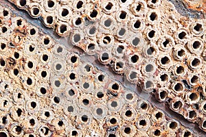 Tube sheet or plate of heat exchanger or boiler closeup texture macro diagonal background full of insoluble hard mineral deposits