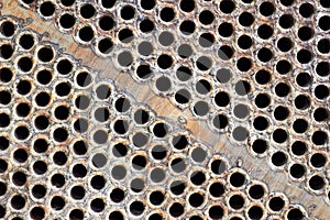 Tube sheet plate of heat exchanger or boiler closeup texture macro diagonal background with insoluble hard mineral
