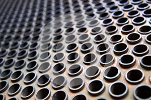 Tube sheet or plate of heat exchanger or boiler selective focus shot at an angle closeup texture industrial background