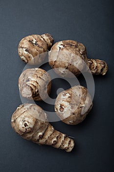 Tubers of Jerusalem artichoke on black background