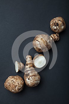 The tubers of the organic unpurified topinambur Jerusalem artichoke, Helianthus tuberosus, sunroot, sunchoke on black background