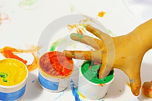 Tubes with colorful bright colors with baby`s fingers stuck inside