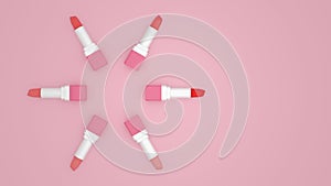 Tubes of lipstick of different shades laid out in a circle on a pink background