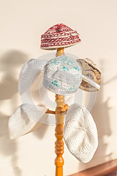 Tubeteika National Islamic headdress with embroidered skull cap traditional oriental Muslim on hat hangers in Mosque. Praying for photo