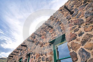 Tucson, Arizona- Stone house with vigas and green window frame