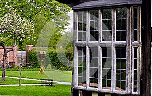 Tudor house exterior detail built in 1590 detail of window and garden outdoors Blakesley hall closeup