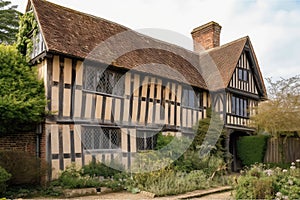 tudor house, with wooden exterior and weathered shingles, viewed from the front