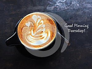 Tuesday coffee. With morning coffee with text greeting on black wooden table background. Top view. Good Morning Tuesday