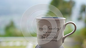 Tuesday cup of tea or coffee on the table with inspirational text message on it - Hello Tuesday. Take nothing for granted.