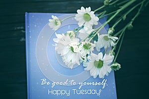 Tuesday quote - Be good to yourself. Happy Tuesday. Text message on blue book with flowers on vintage background.