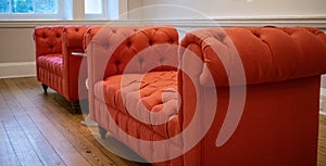 Tufted orange settee couches in a reception office setting