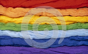 Tufts of wool of different colors parallel to each other form a rainbow. Conceptual photo