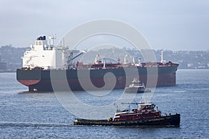 Tug boat escorting cargo ship, oil tanker.