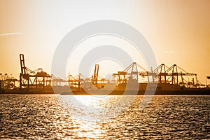 Tug boat in harbor with cranes