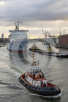 Tug boat taking out the ship from the harbor photo