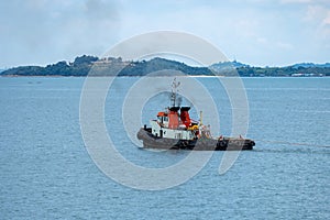 Tug boat tows bulk cargo lighter barge along Singapore strait