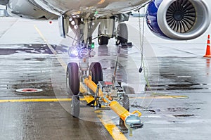 TUG carrier for airplane, trailer front landing gear pushback aerodrome tractor with airplane on the runway in airport