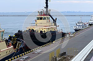 The tug is moored to the wall of the pier in the port of Odessa.