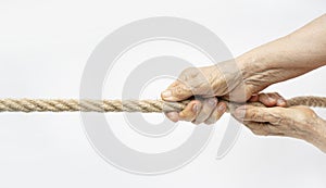 Tug of war. Aged wrinkled hands pull the rope towards