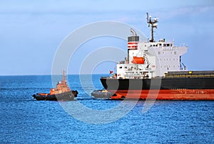 Tugboat assisting bulk cargo ship