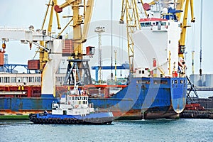 Tugboat assisting bulk cargo ship