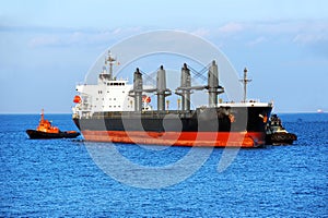 Tugboat assisting bulk cargo ship