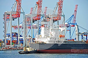 Tugboat assisting bulk cargo ship