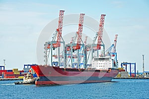 Tugboat assisting bulk cargo ship