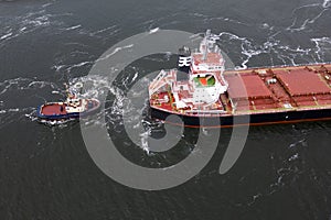 A tugboat assisting a bulkcarrier