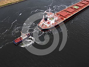 A tugboat assisting a bulkcarrier