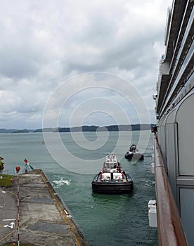 Tugboat assists and maneuvers cruise ship in Panamas Canal