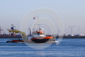 Tugboat with crane passing by on the river